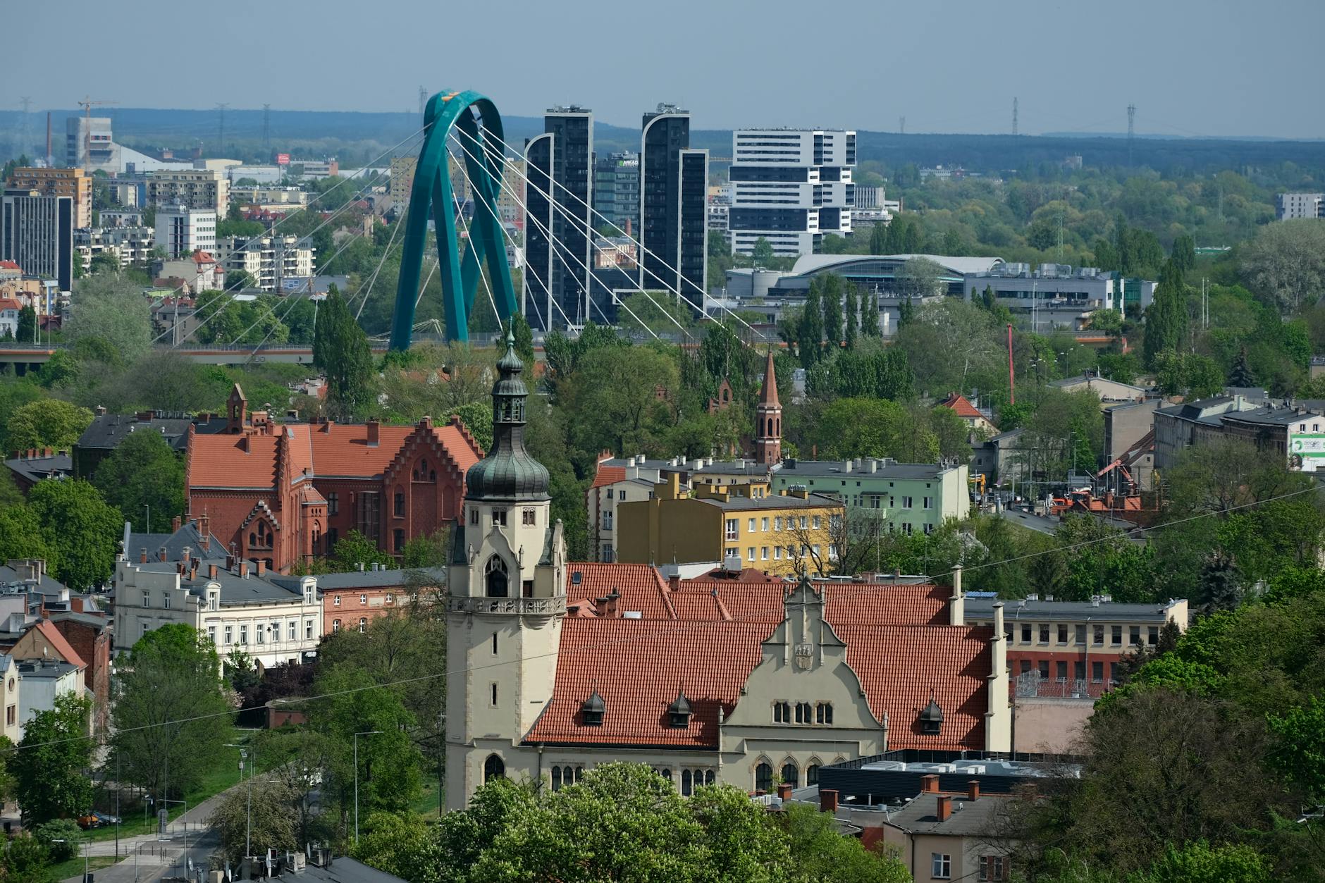 Panorama Chojnic z widoczną wieżą kościoła na tle zielonych terenów i Borów Tucholskich.